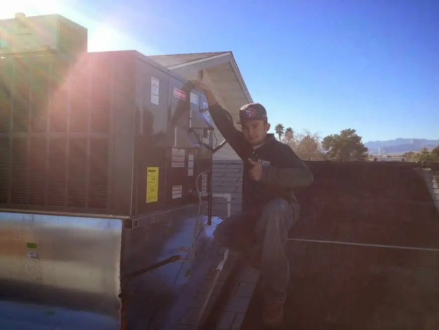 HVAC technician performing AC Tune-Up on a rooftop unit in Ottawa